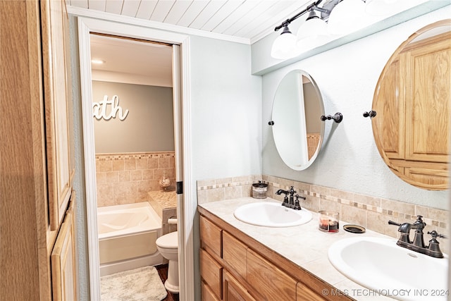 bathroom featuring vanity, ornamental molding, toilet, and a tub to relax in