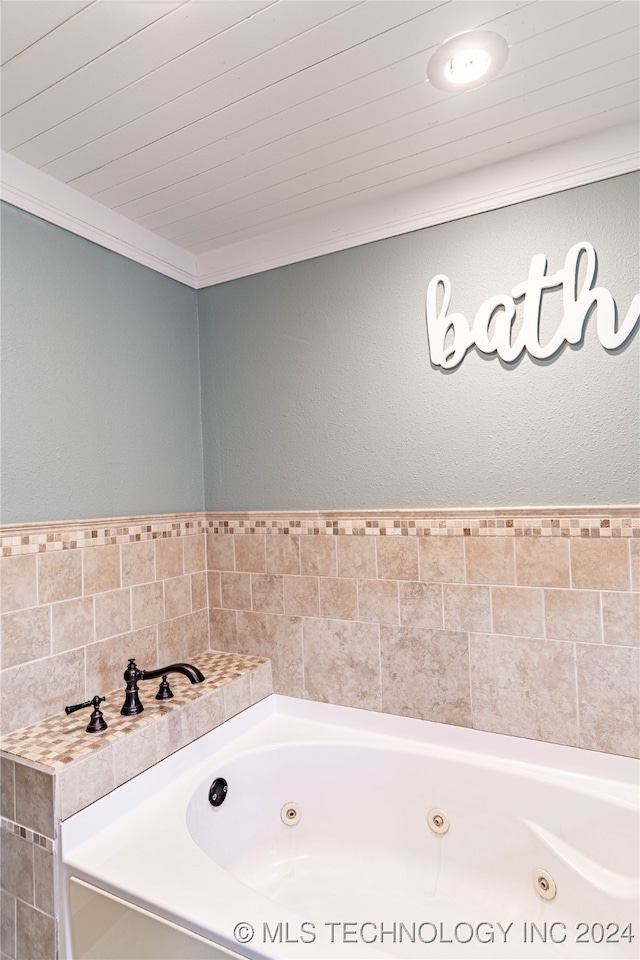 bathroom with crown molding and a bathing tub