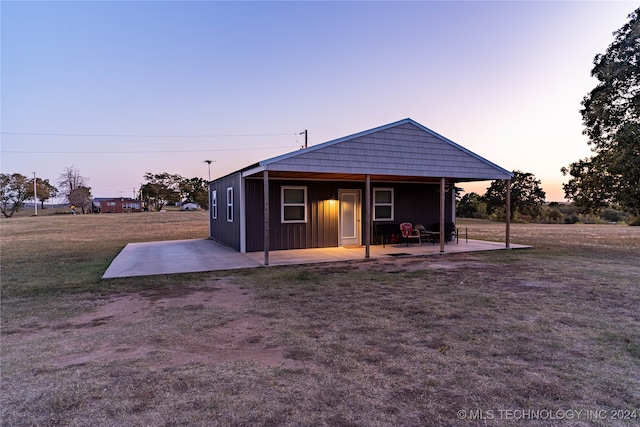 view of front of house with a patio area and a yard