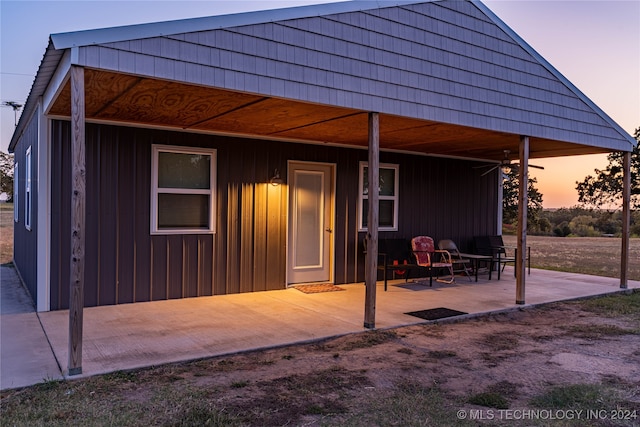 back house at dusk featuring a patio area