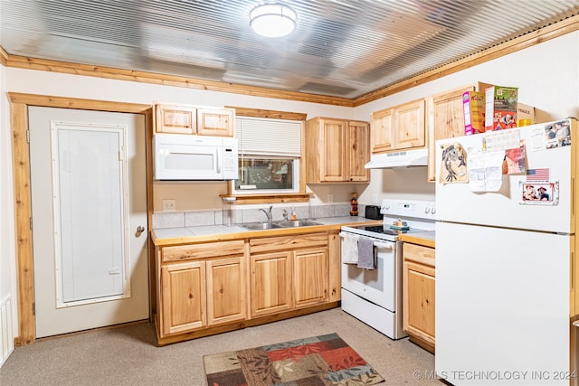 kitchen with white appliances, light brown cabinetry, sink, and tile counters