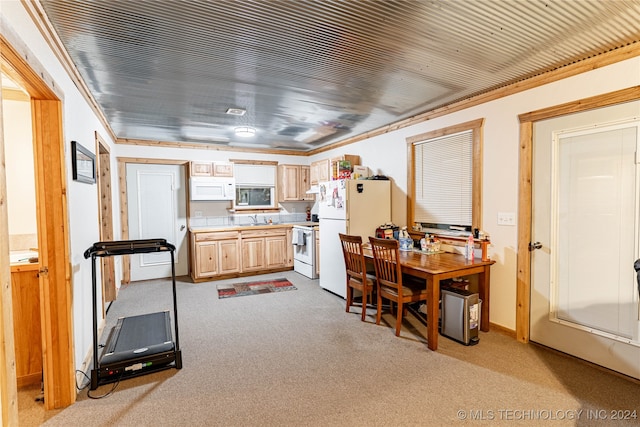 kitchen with sink, crown molding, light colored carpet, and white appliances