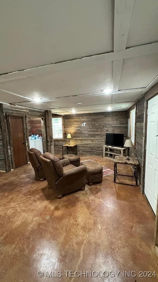 living room with concrete floors and wooden walls