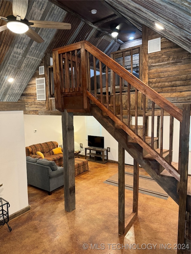 living room featuring wooden walls, vaulted ceiling, carpet floors, and ceiling fan