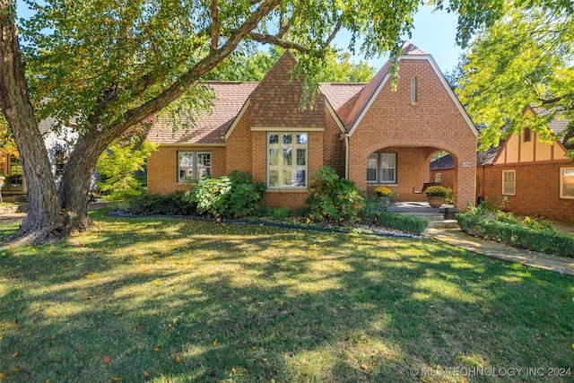 tudor-style house with a front yard