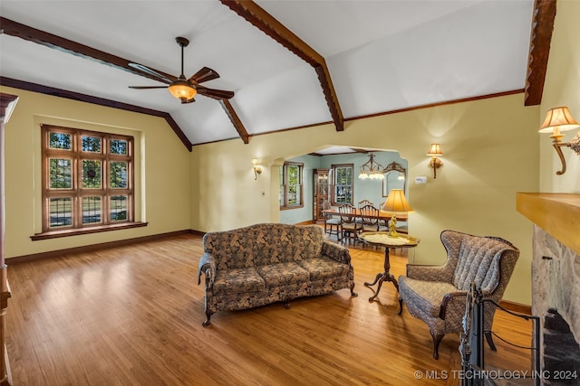 living room with vaulted ceiling with beams, light hardwood / wood-style flooring, a fireplace, and ceiling fan