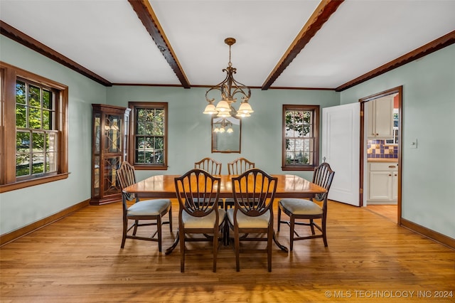 dining space with light hardwood / wood-style floors, crown molding, a chandelier, and a wealth of natural light