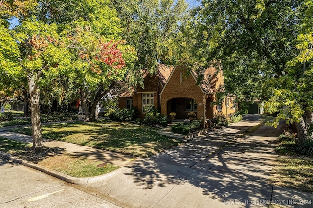 tudor-style house featuring a front lawn