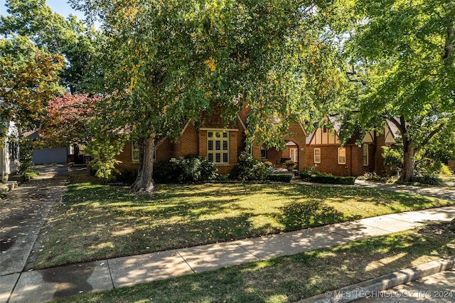 obstructed view of property featuring a front lawn and a garage