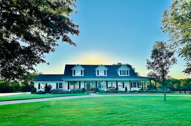 view of front of house featuring covered porch and a lawn