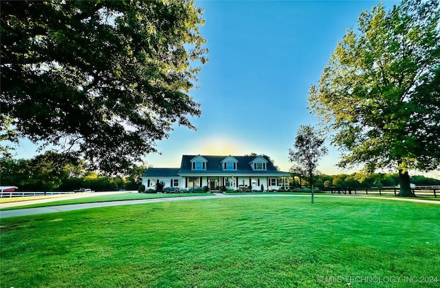 cape cod home featuring a front lawn