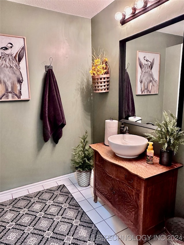 bathroom with vanity, a textured ceiling, and tile patterned flooring