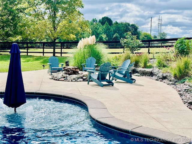 view of swimming pool with a patio, a fire pit, and a lawn