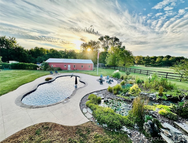 view of property's community featuring a patio, a rural view, a yard, and a pool