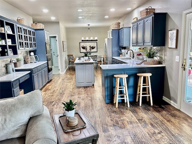 kitchen with sink, stainless steel fridge, decorative backsplash, and kitchen peninsula