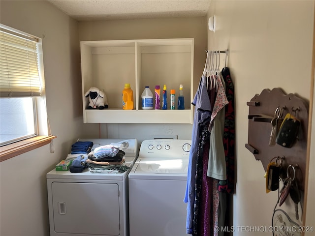 laundry area featuring a textured ceiling and washing machine and clothes dryer