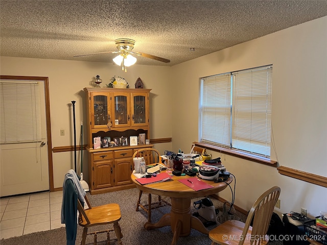 tiled dining room with ceiling fan and a textured ceiling