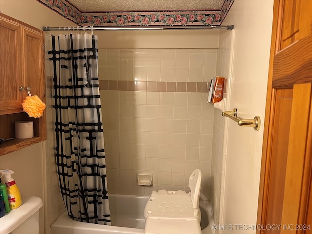 bathroom with shower / bath combo with shower curtain, a textured ceiling, and toilet