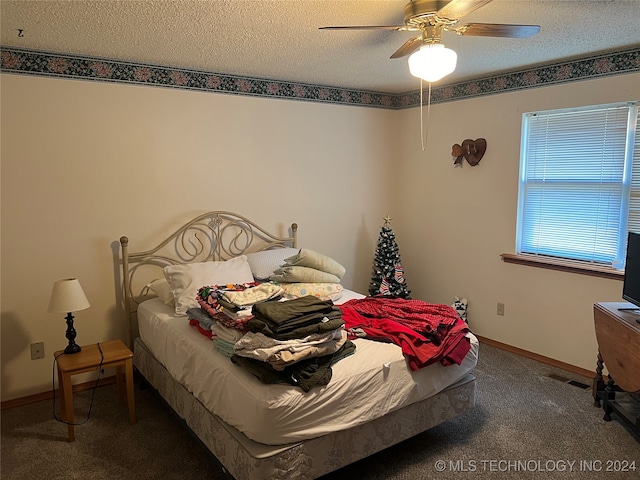 bedroom featuring carpet floors, a textured ceiling, and ceiling fan