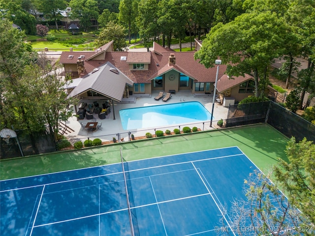 view of tennis court featuring a patio area