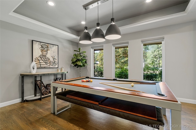 recreation room featuring pool table, a tray ceiling, and dark wood-type flooring