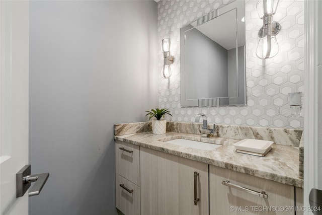 bathroom with vanity and tasteful backsplash