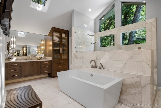 bathroom featuring separate shower and tub, high vaulted ceiling, tile walls, a skylight, and vanity