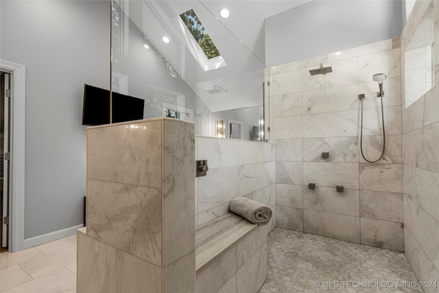 bathroom with lofted ceiling with skylight and a tile shower