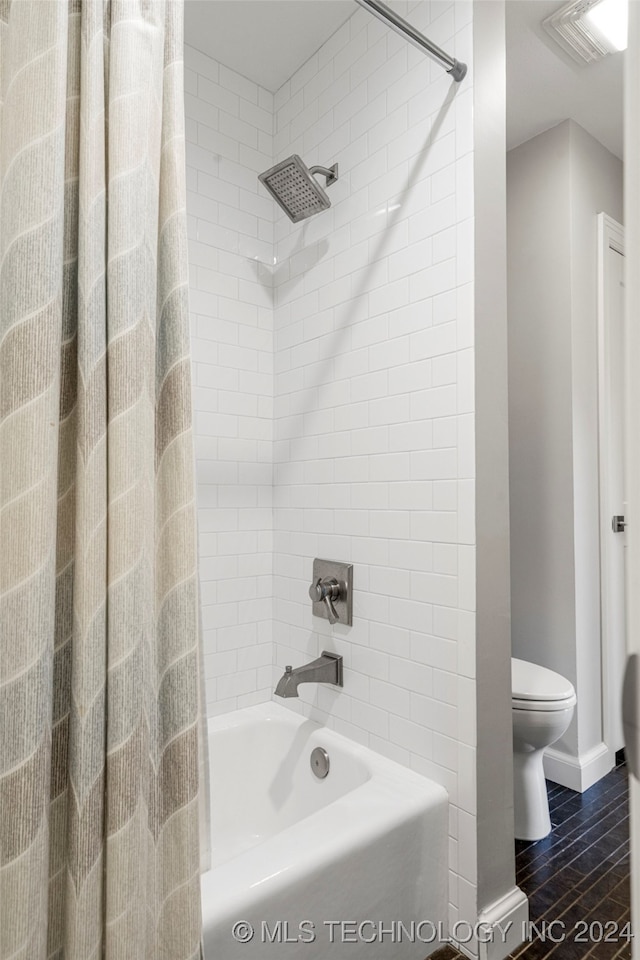 bathroom featuring shower / tub combo with curtain and toilet