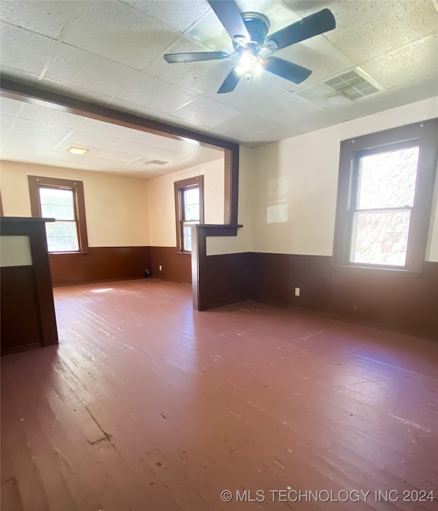 spare room featuring a drop ceiling, hardwood / wood-style floors, and ceiling fan