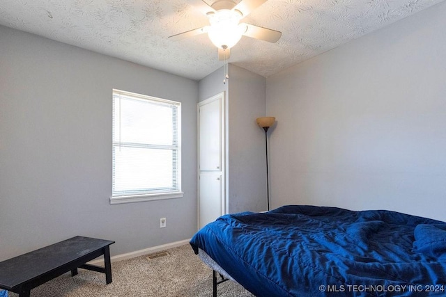 carpeted bedroom with visible vents, baseboards, and a ceiling fan