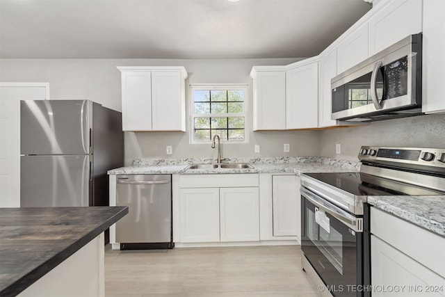 kitchen with appliances with stainless steel finishes, sink, and white cabinets