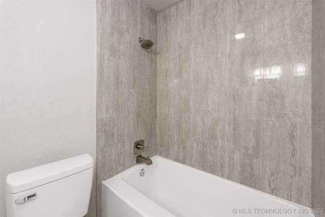 bathroom featuring toilet and tiled shower / bath combo