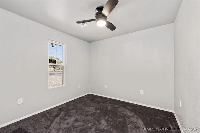 empty room featuring ceiling fan and dark carpet