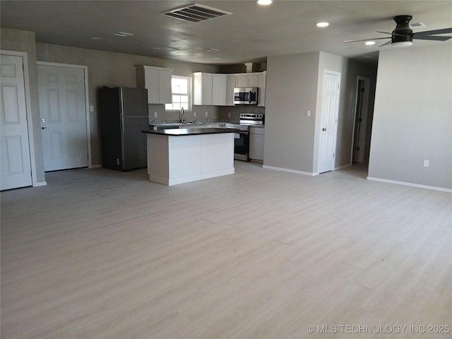 kitchen featuring white cabinetry, a center island, light wood-type flooring, ceiling fan, and stainless steel appliances