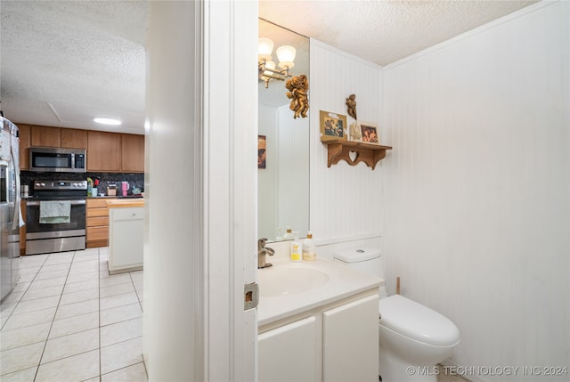 bathroom featuring tasteful backsplash, a textured ceiling, toilet, vanity, and tile patterned floors