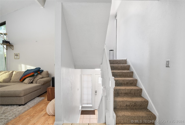 staircase featuring hardwood / wood-style flooring and vaulted ceiling