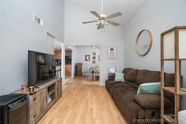 living room featuring high vaulted ceiling, light wood-type flooring, and ceiling fan