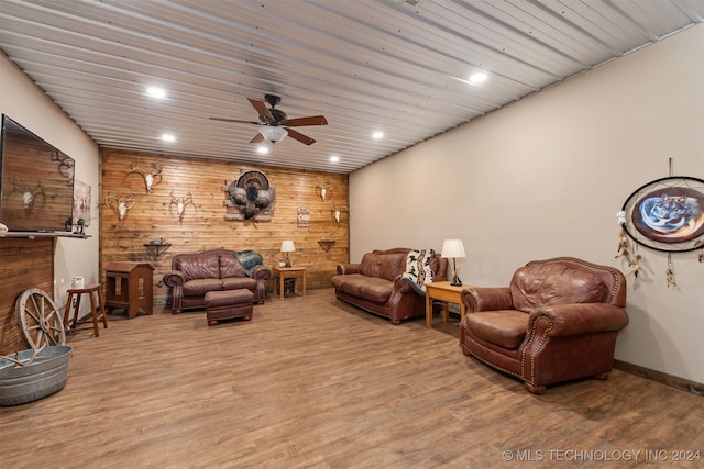 living room featuring ceiling fan, wood walls, wood-type flooring, and wooden ceiling