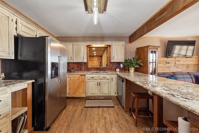 kitchen featuring light hardwood / wood-style floors, appliances with stainless steel finishes, sink, and cream cabinets