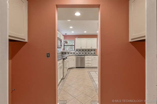 kitchen featuring backsplash, white cabinetry, light tile patterned floors, and appliances with stainless steel finishes