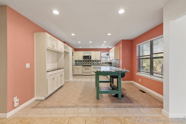 kitchen featuring white cabinetry, sink, white electric stove, backsplash, and light tile patterned flooring