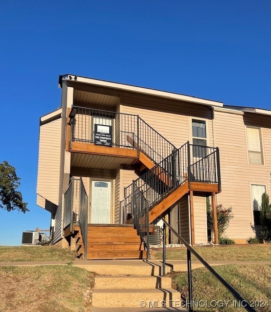 view of front of home with central air condition unit and a front lawn