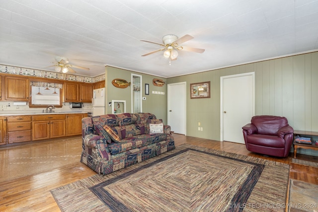 living room with sink, ceiling fan, and light hardwood / wood-style flooring