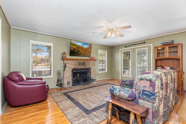 living room featuring a fireplace, plenty of natural light, light wood-type flooring, and ornamental molding