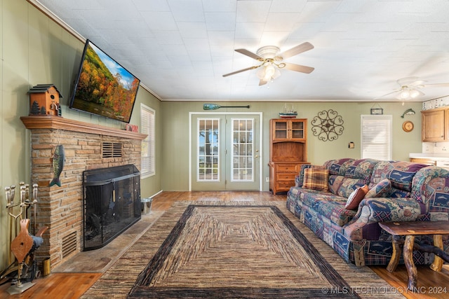 living room featuring a brick fireplace, ceiling fan, light wood-type flooring, and ornamental molding