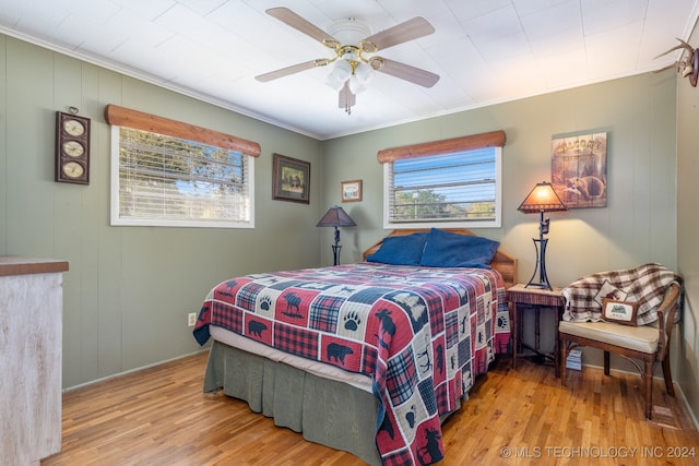 bedroom with light hardwood / wood-style floors, ceiling fan, and crown molding