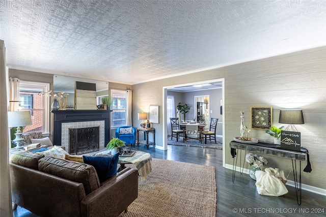 living room featuring dark wood-type flooring, a textured ceiling, and a wealth of natural light