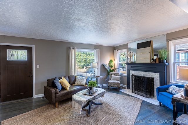 living room featuring a textured ceiling, dark hardwood / wood-style flooring, and a tile fireplace