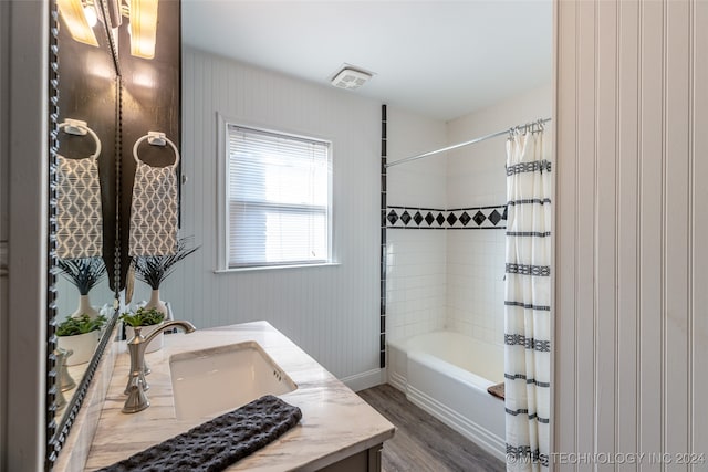 bathroom featuring vanity, wood walls, shower / bath combo with shower curtain, and hardwood / wood-style floors